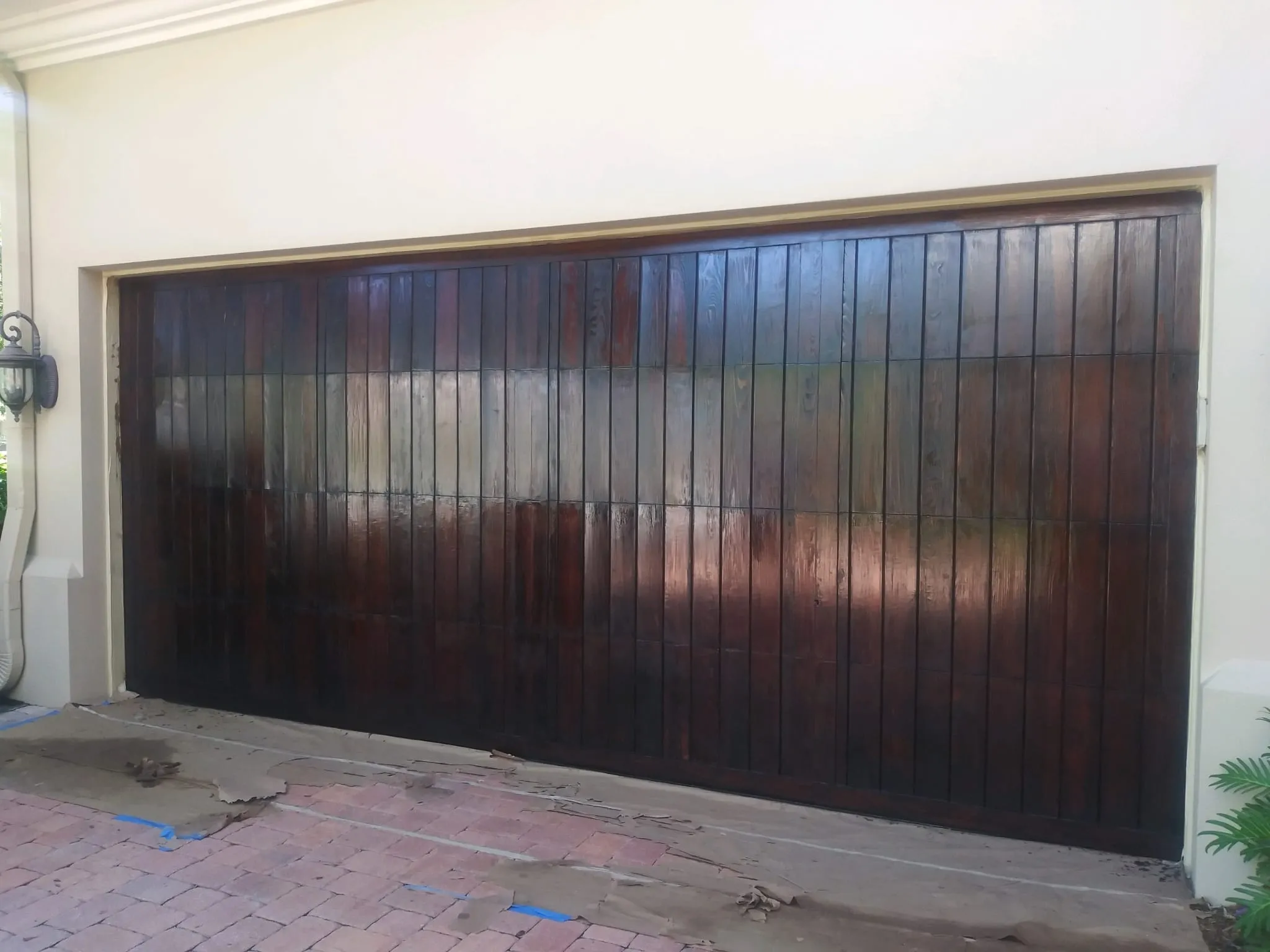 Puerta de garaje de madera restaurada y barnizada