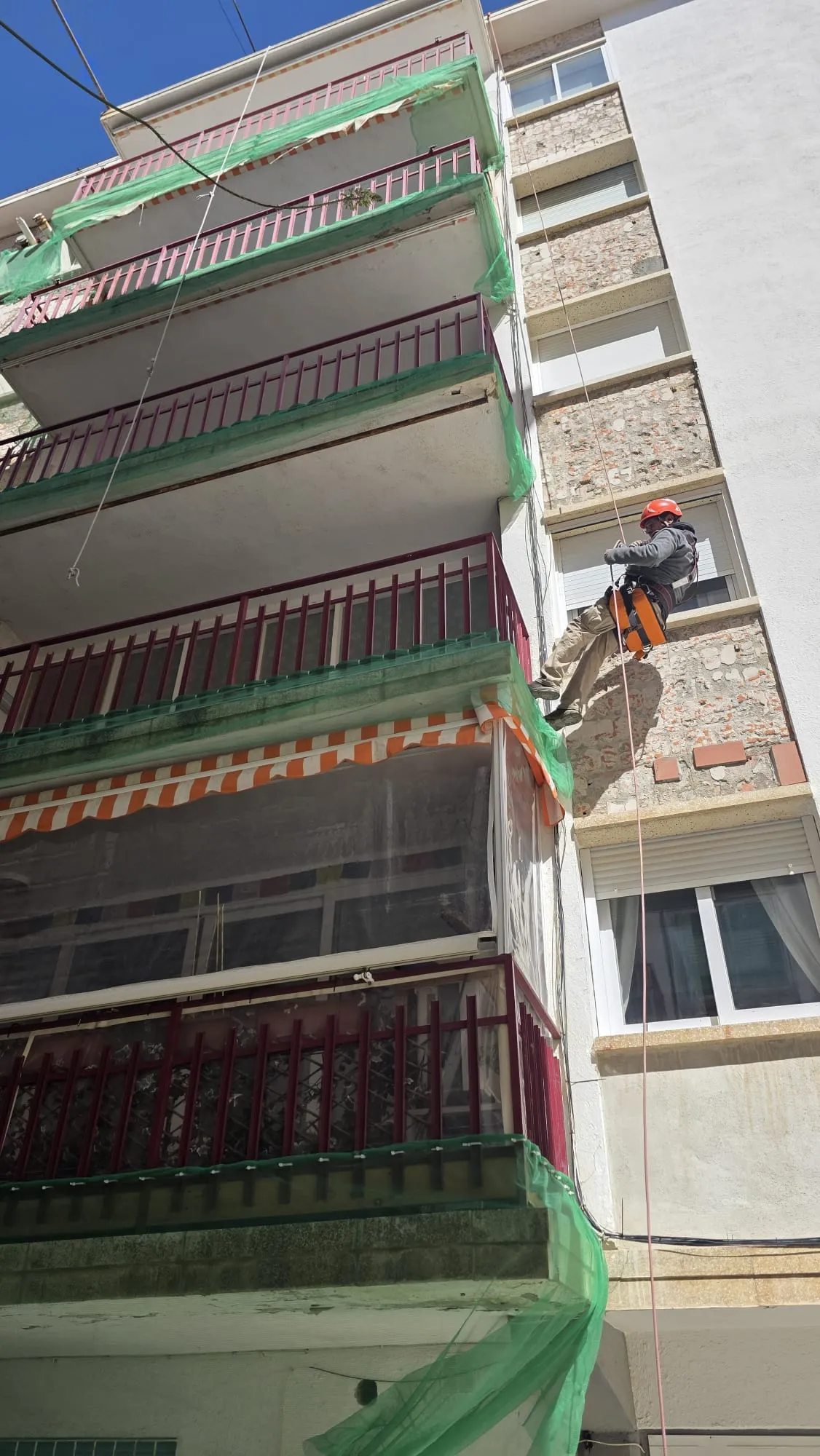 Operario en trabajos verticales sobre la fachada de un edificio